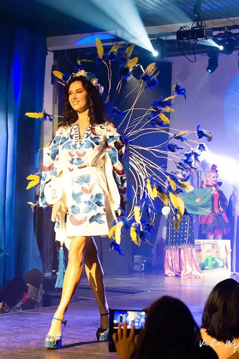 Iryna Malpa on the runway in a blue feathered couture look.