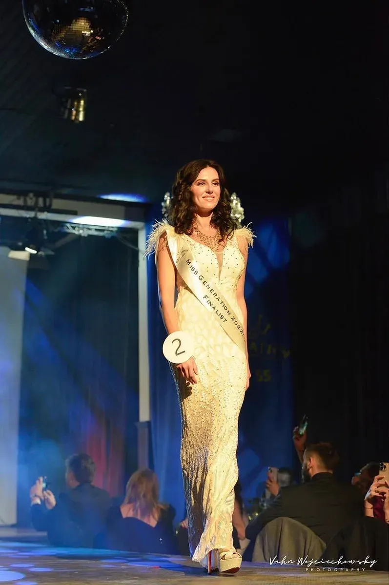 Iryna Malpa on stage in a gold gown as a beauty-pageant finalist.
