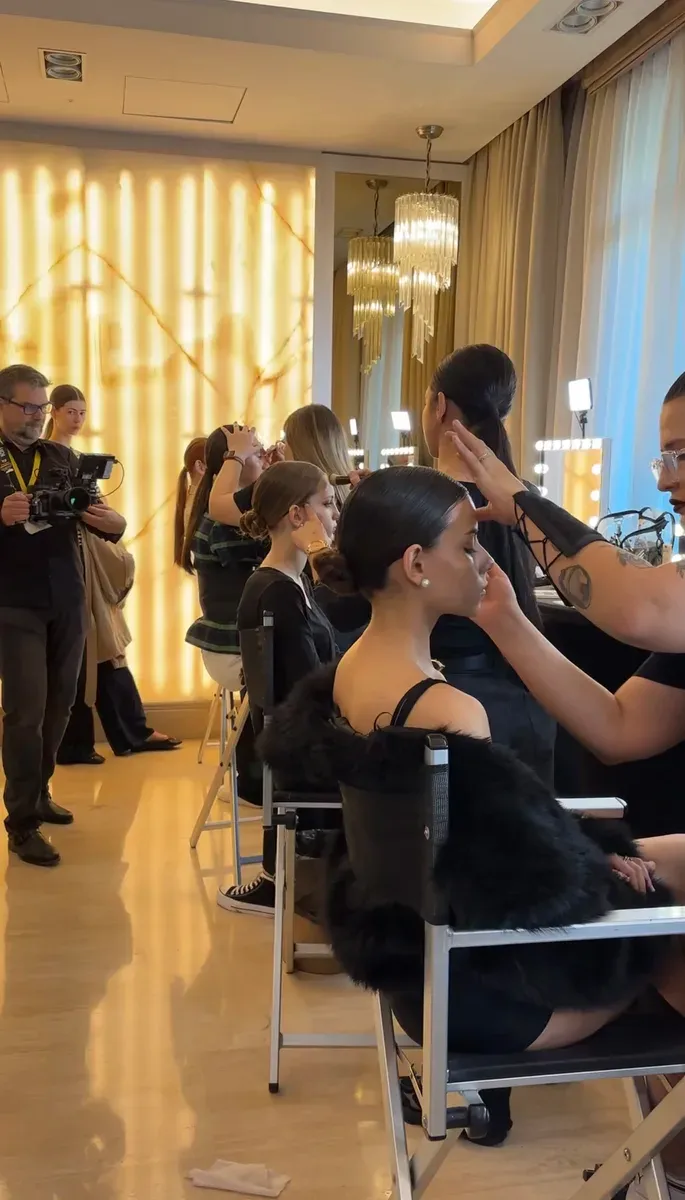 Students backstage in hair and makeup before a fashion show in Marbella.