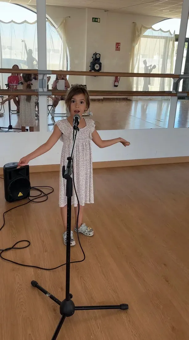 A young girl speaking into a microphone during a public-speaking class in Marbella.