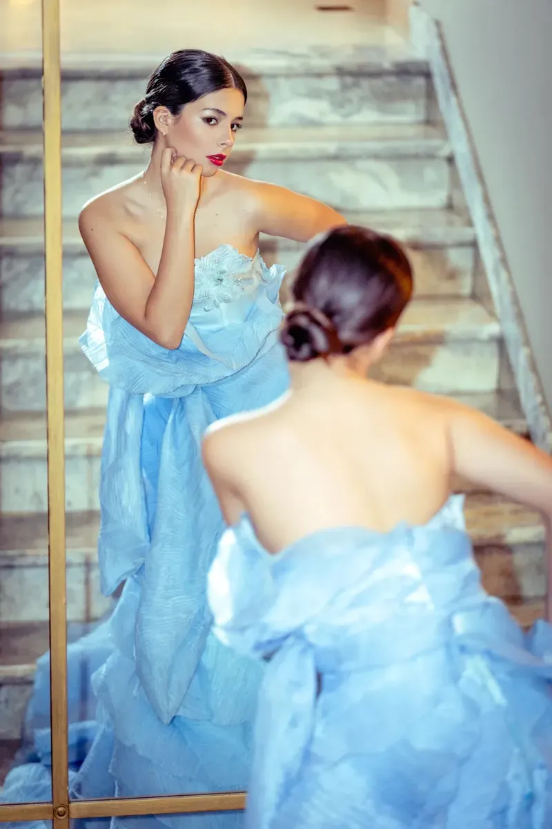 Editorial fashion photograph of a young model in a couture gown.